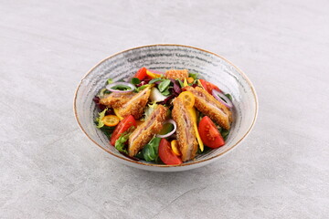 Crunchy thai style chicken salad in bowl over light stone background. Close up view