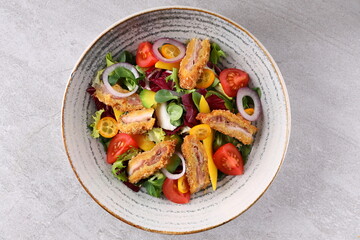 Crunchy thai style chicken salad in bowl over light stone background. Close up view