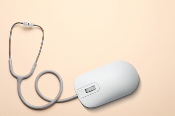 Computer mouse with stethoscope on beige background, top view. Online medicine