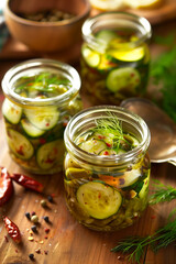 homemade pickled vegetables in glass jars, pickled cucumbers, carrots, onions and garlic with spices