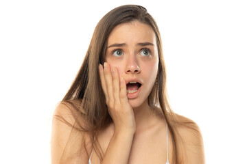 Fototapeta premium portrait of a young shocked teenage girl without makeup on a white background