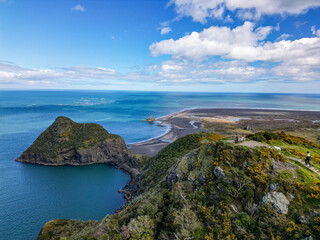 Hikers watch the view astonishing view of Whatipu Beach from bench on Omanawnui track. Auckland,...