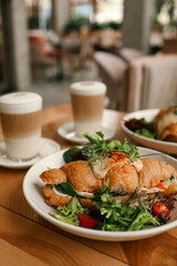 croissant sandwiches and coffee cups on wooden table