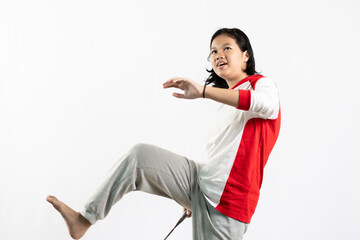 Young Asian woman wearing Indonesian clothing is holding a racket and playing badminton. isolated white background