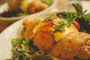 croissant sandwiches and coffee cups on wooden table