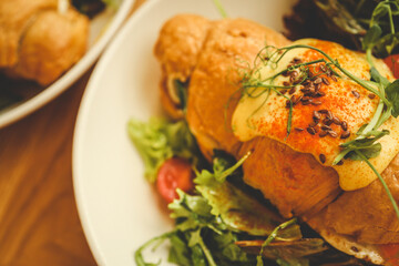 croissant sandwiches and coffee cups on wooden table