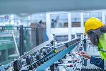 Portrait of African woman worker beautiful face with eye confident and wearing working suite dress and safety helmet at heavy machine in industry factory. Engineer  worker concentrate on workplace.