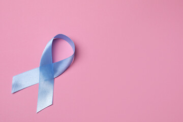 International Psoriasis Day. Light blue ribbon as symbol of support on pink background, top view....