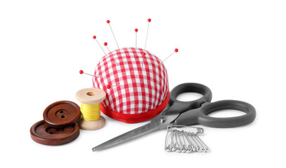 Pincushion with sewing pins, scissors, spool of thread and buttons isolated on white