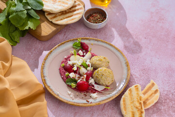 red beetroot hummus with falafel, lemon, sesame, olive oil, pita. Middle eastern, Jewish, arabic cuisine.