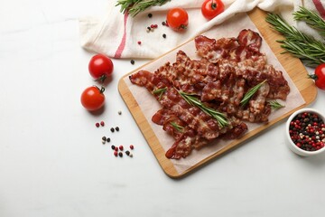 Slices of tasty fried bacon with different spices and tomatoes on light table, flat lay. Space for text