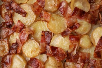 Delicious baked potatoes and bacon as background, top view