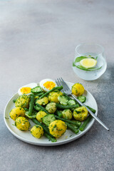 Delicious lunch or dinner, boiled young potatoes with asparagus beans and young fresh cucumbers, boiled eggs and fresh berries, refreshing water with lemon and mint