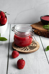 Fresh strawberry jam. on a wooden background. berries
