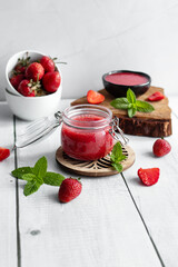 Fresh strawberry jam. on a wooden background. berries