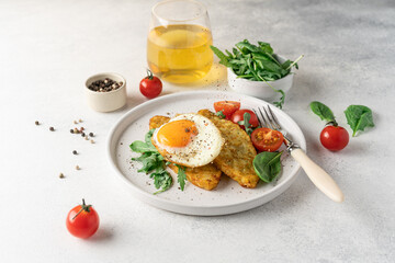 Egg, hashbrown and salad in plate on white background with copy space