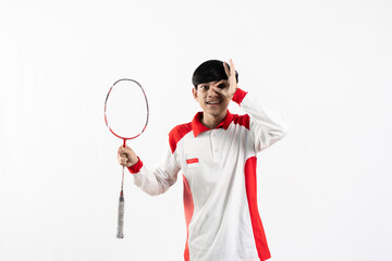 Young Asian man wearing Indonesian clothing is holding a racket and playing badminton. isolated white background