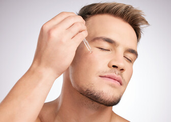 Cosmetics, man and liquid serum on face for skincare, wellness and hygiene in studio white...