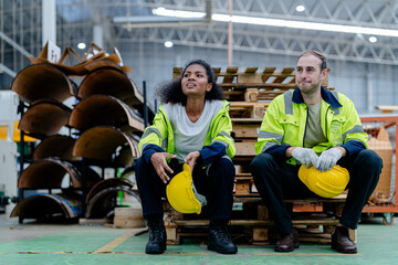 workers engineering sitting after work with working suite dress and hand glove in the front machine. Concept of smart industry worker are resting.