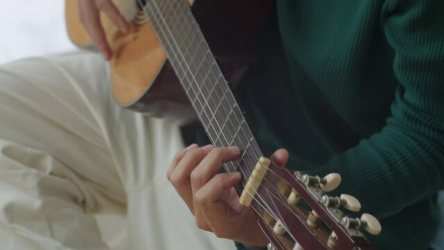 Cropped shot of unrecognizable male musician playing guitar while working on new song chords at home