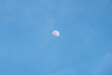 Moon in the blue sky with white clouds, good weather day