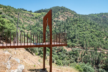 Fototapeta premium Miradouro em estrutura metálica com tons alaranjados de ferrugem com vistas para o rio Tua e grandes montanhas cobertas por pinheiral ao fundo em Portugal