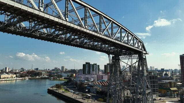 La Boca ferry bridge on the riachuelo and panoramic view of Buenos Aires, Argentina. Aerial camera rises from the bridge and shows the city