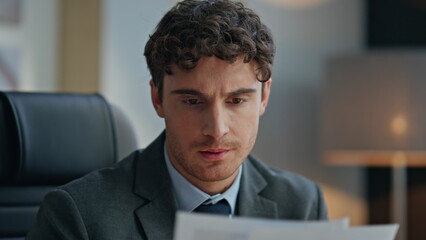 Fototapeta premium Experienced businessman reading documents at desk closeup. Pensive man thinking