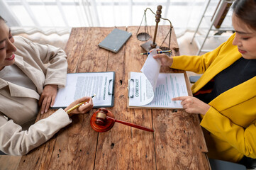 Two women are sitting at a table with papers in front of them
