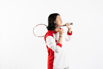 Young Asian woman wearing Indonesian clothing is holding a racket and playing badminton. isolated white background