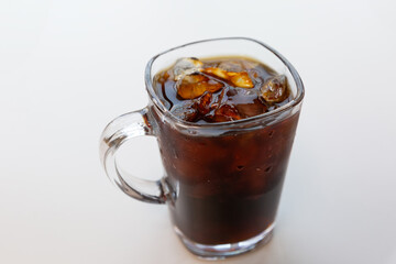 A cup of iced americano coffee on the table.