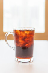 A cup of iced americano coffee on the table.