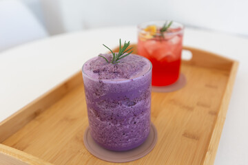 Glass of blueberry smoothie and Grapefruit Ade on table.