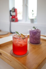 Glass of blueberry smoothie and Grapefruit Ade on table.