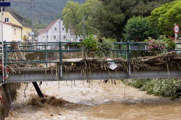 Fallen trees on the bridge and boxes with beautiful flowers. The consequences of flooding in an Austrian city. Deutschfeistritz, Austria - 09 Jun 2024