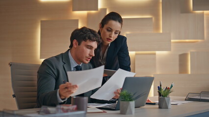Office team watching papers working together at computer workplace closeup