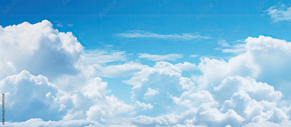 Poster fluffy clouds float gracefully in the blue sky above peaceful water, creating a serene and picturesq