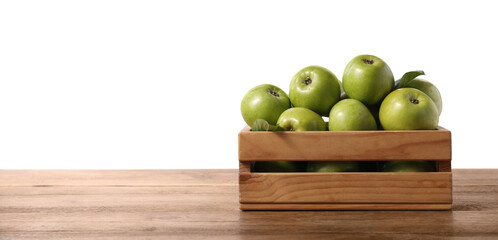 Ripe green apples in crate on wooden table against white background. Space for text