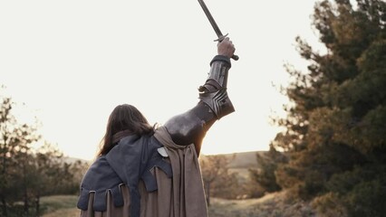 Warrior raises his sword up - celebrating victory