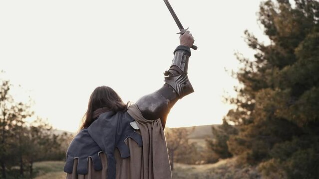 Warrior raises his sword up - celebrating victory
