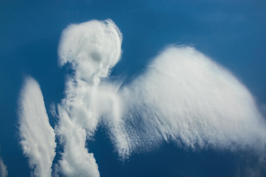 Cloud in the shape of an angel. Daytime blue sky with natural clouds. Pareidolia