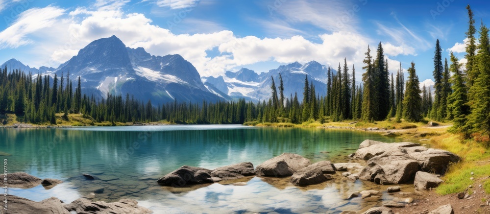 Leinwandbilder scenic view of a serene mountain lake surrounded by rocks and trees with the majestic rocky mountain
