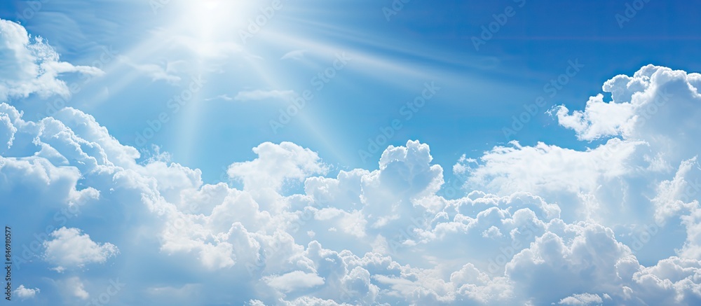 Poster Sun piercing through beautiful white clouds in a clear blue sky, creating a radiant scene. with copy space image. Place for adding text or design