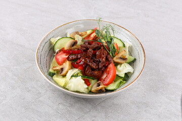 Asian beef salad with vegetables and nuts in a white bowl on a dark background. Asian food concept.