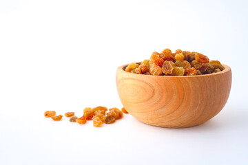 Golden dried raisins in wooden bowl isolated on white background