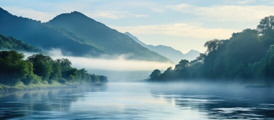 Serene view of a river with a boat gliding through morning mist, surrounded by majestic mountains. with copy space image. Place for adding text or design