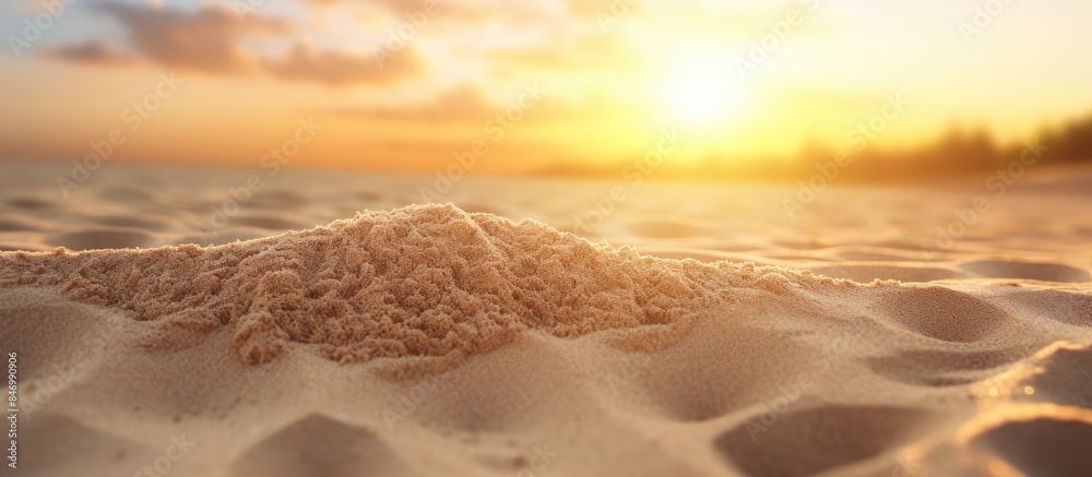 Poster sand pile with textured surface illuminated by warm sunset light on a peaceful beach setting. with c