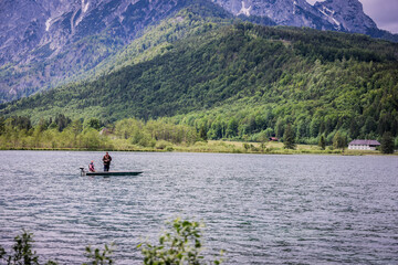 A beautiful view on the Ehrwalder Almsee and the Zugspitze on a sunny summer day in Austria, 2024, pescadores, haciendo su labor del dia para llevar comida a casa