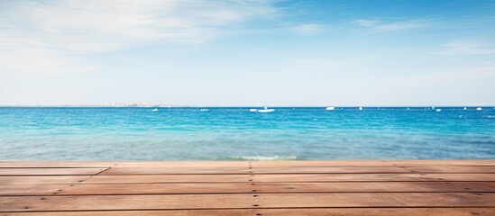 Fototapeta premium Wooden deck overlooking the ocean, with a view of boats in the distance. with copy space image. Place for adding text or design
