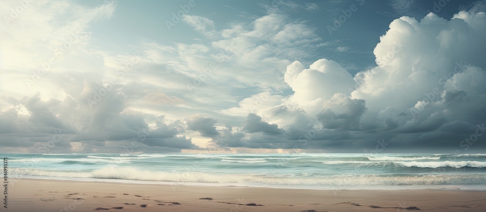 Poster Enjoying a leisurely walk on the beach, a man is seen carrying a surfboard under the cloudy sky. with copy space image. Place for adding text or design